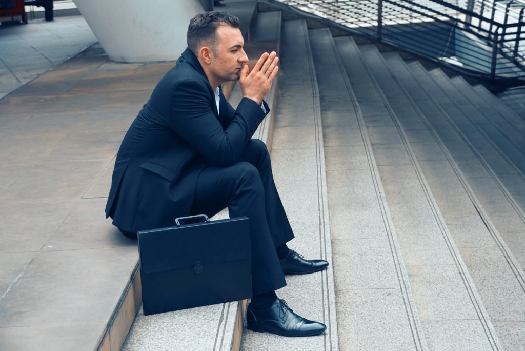 Businessman sit on the stairs and pray for apply job , layoff concept.