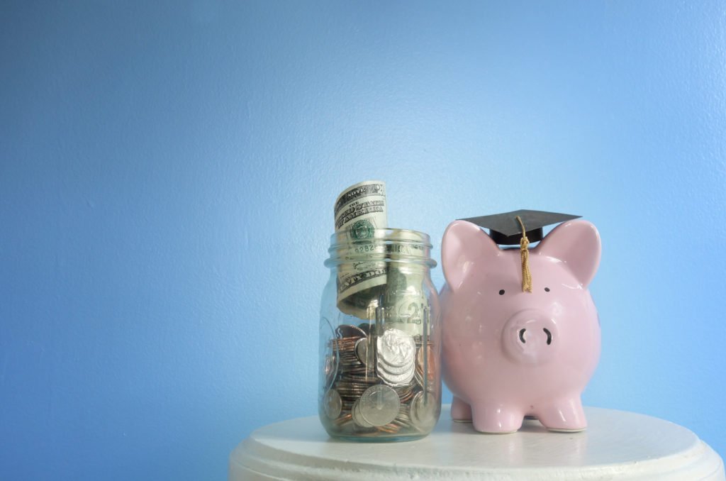 Piggy bank with graduation cap and coin jar