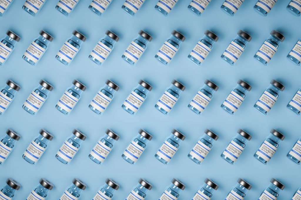 pattern of vaccine bottles against covid-19 with injection fluid. Coronavirus vaccine. Blue background. 3D ilustration