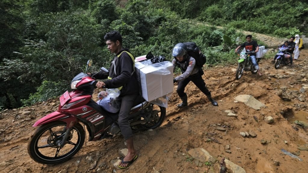 Election ballots and boxes carried across Indonesia by motorcycle, boat, horse and on foot - The Associated Press