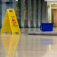 slip and fall accident concept Yellow caution sign showing warning of slippery wet floor